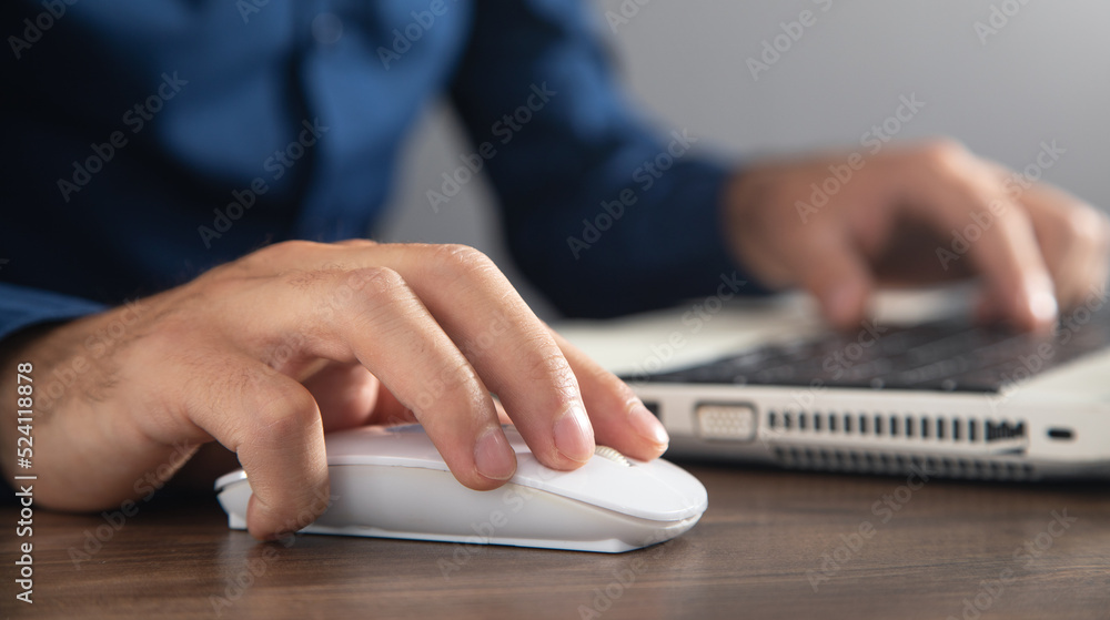 Wall mural male hand clicking computer mouse and typing in computer keyboard. internet. business. technology