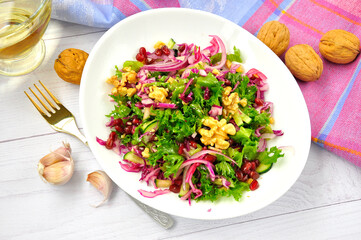 Healthy vegetarian Salad with pomegranate, walnuts and lettuce leaves.