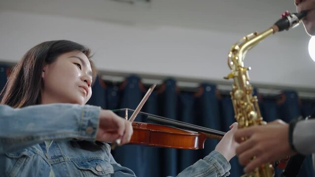 The saxophones in a classical orchestra are performing together in the band.
