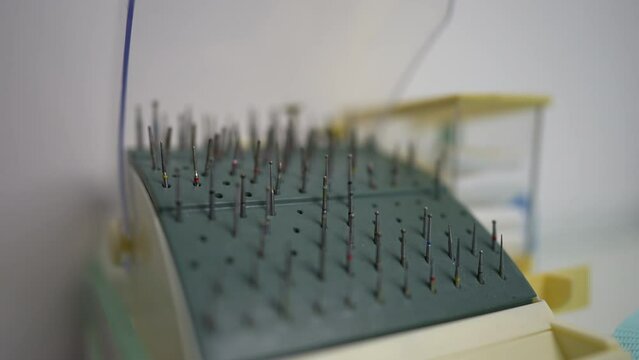 Close-up bur stand in dental clinic indoors with rack focus moving back to front. Professional equipment tool in hospital with no people. Dental health and medicine concept