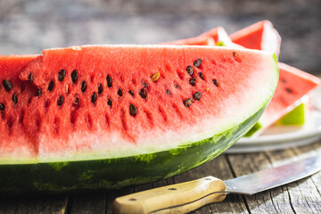 Slices of red watermelon on wooden table.
