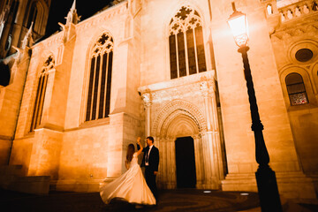 Beautiful bride spinning with perfect dress near great historical building