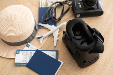 Flat lay composition of vr headset, travel accessories on a wooden floor. Virtual Tourism. Top view.