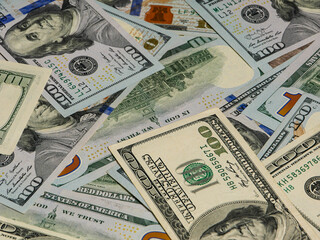 Large pile of hundred dollar bills in background view.