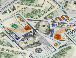 Large pile of hundred dollar bills in background view.