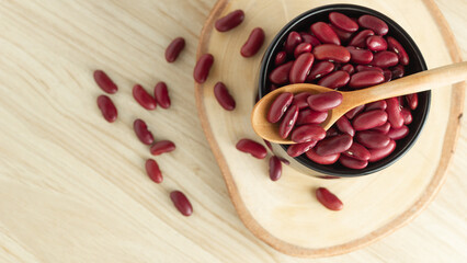red kidney beans in a black bowl and spoon on wooden background, top view, flat lay, top-down, selective focus.copy space.