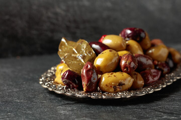 Spicy olives in a silver dish.