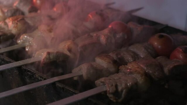 Close-up of lumpy kebab with tomato and ground kebab is grilled on the grill