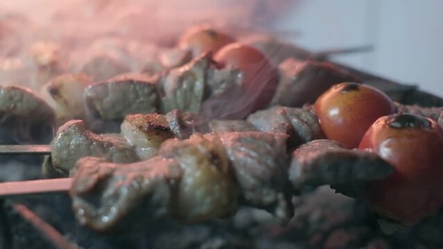 Close-up of lumpy kebab with tomato and ground kebab is grilled on the grill