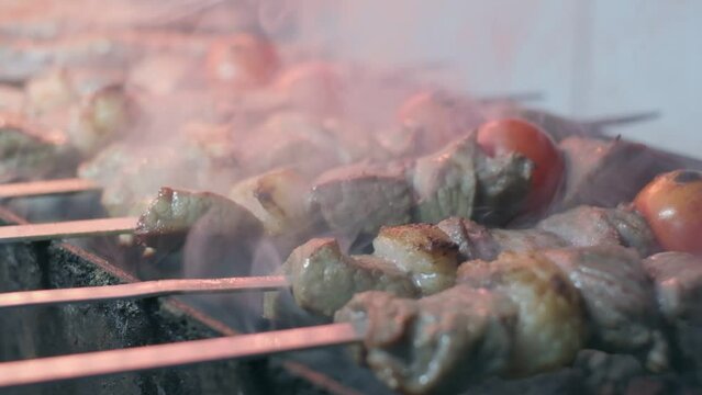 Close-up of lumpy kebab with tomato and ground kebab is grilled on the grill