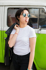 young greaser girl with short hair, posing with a fifties rockabilly style while chewing gum...