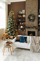 Classic Christmas interior in the living room with a sofa, brown walls, large windows, fireplace and shelves with decor. Cozy New Year's interior with a Christmas tree and a wreath over the fireplace