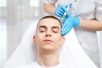 Cosmetologist does prp therapy of a handsome guy in beauty salon. Cosmetology concept.