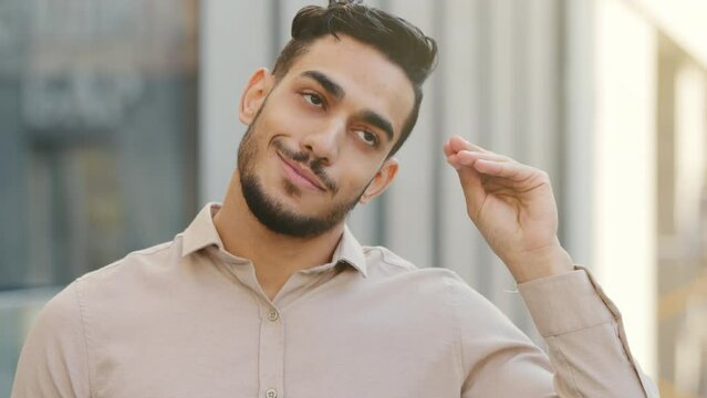 Close up emotional disappointed grimacing male portrait outdoors in city Hispanic Arabian Indian bearded bored business man disappointed showing bla-bla-bla sign with hand blah gesture empty promises