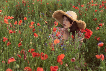 A young girl in a flowering poppy field