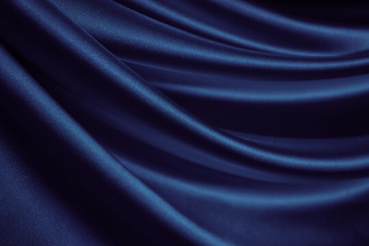 Black blue silk satin. Dark elegant background with space for design. Soft folds. Wavy. Shiny smooth fabric. Luxurious. Valentine, 14.02, Christmas, New year, festive.