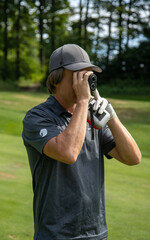 Male golfer using golf distance tool