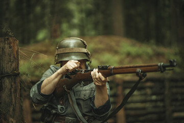 Fototapeta premium A soldier of the Finnish army during World War II, shoots a rifle in the forest.