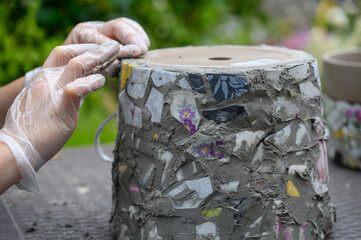 People decorate earthenware with mosaic techniques in the master class or in the fresh air in the...