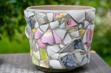 Homemade mosaic flower pot with porcelain pieces. Recycling, broken tableware, ceramics, crafts, mosaics.