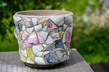 Homemade mosaic flower pot with porcelain pieces. Recycling, broken tableware, ceramics, crafts, mosaics.