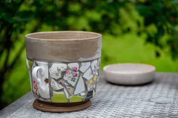 Homemade mosaic flower pot with porcelain pieces. Recycling, broken tableware, ceramics, crafts, mosaics.