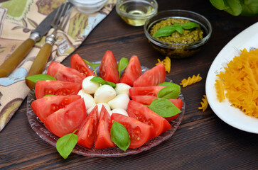 antipasto caprese, tomatoes, mozzarella and basil on the plate close up