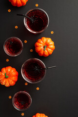 Halloween party concept. Top view vertical photo of drink in glasses with floating spiders straws...