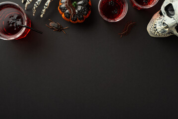 Halloween concept. Top view photo of glasses with blood punch floating spiders creepy skull...