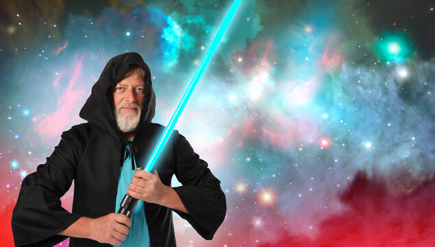 a man holds a lightsaber in a Halloween costume