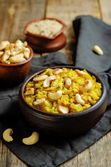 Curry rice with fried onion and roasted cashews on a wood background