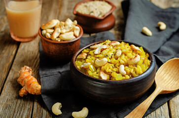 Curry rice with fried onion and roasted cashews on a wood background