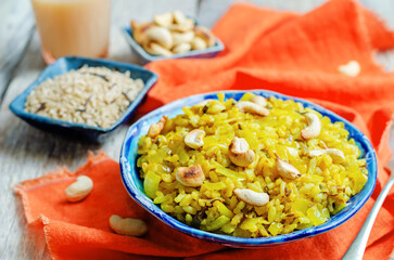Curry rice with fried onion and roasted cashews on a wood background.