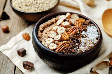 Chocolate quinoa breakfast with coconut shaving, pecan, hazelnut and chocolate slices