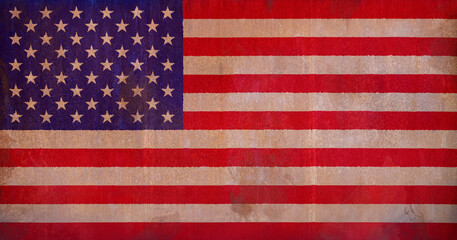 Full frame front view photo of a weathered American (United States of America or USA) flag painted on a rusty, grunge and dirty wall.