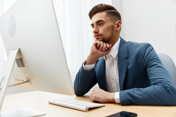 Fototapeta premium handsome businessman wearing glasses works at a computer office technologies
