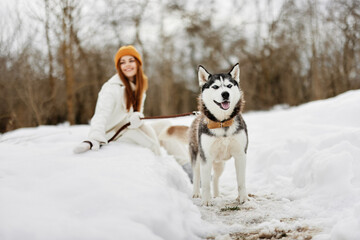 cheerful woman winter clothes walking the dog in the snow winter holidays