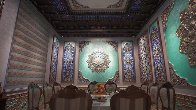 Dining room with richly colored walls and ceiling with Arabic-oriental patterns and rosettes