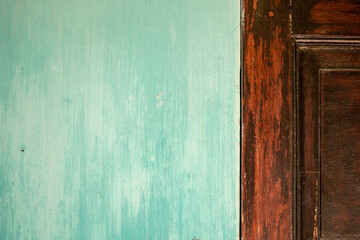 Pared celeste antigua con puerta de madera. Fondo para cartelería o diseño