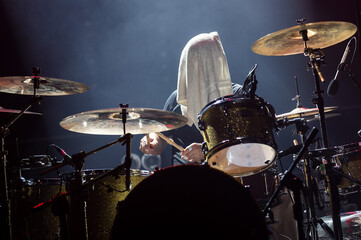 Drummer with a towel on his head during rock concert