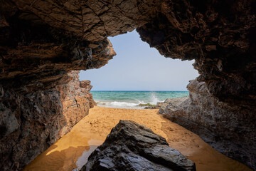 Cave by the sea and girl taking a bath. Calblanque Regional Park in Murcia