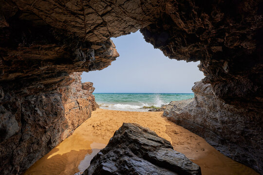 Cave by the sea and girl taking a bath. Calblanque Regional Park in Murcia