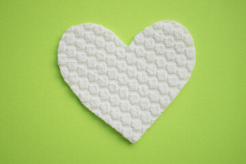 White fabric heart on green table