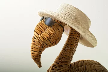 Fotobehang Wicker flamingo dressed in straw hat and sun glasses © JohnBlottman