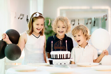 Music and piano birthday party. Kid with cake.