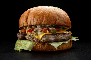 Hamburger with beef and hot vegetables on a black background
