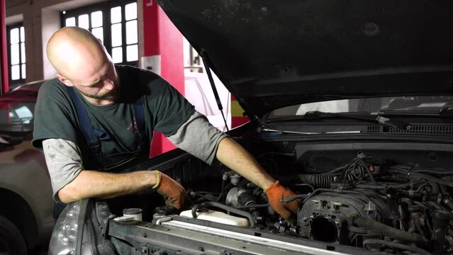auto mechanic is diagnosing an SUV engine. auto repair station.