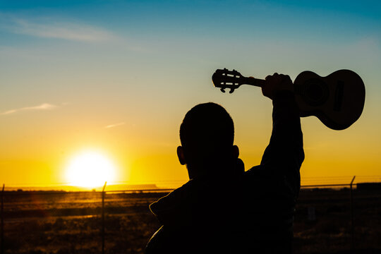 Musician and a little guitar called cavaco during the sunrise in Arizona