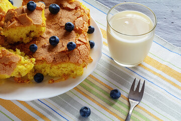 handmade sponge cake or sponge biscuit with blueberries on white ceramic plate.
