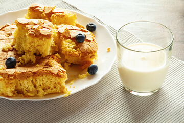 handmade sponge cake or sponge biscuit with blueberries on white ceramic plate.